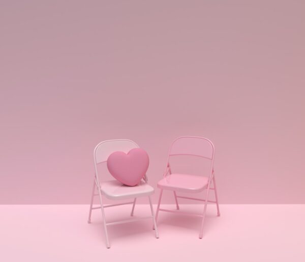 a pink chair and a white chair with a heart shaped pillow